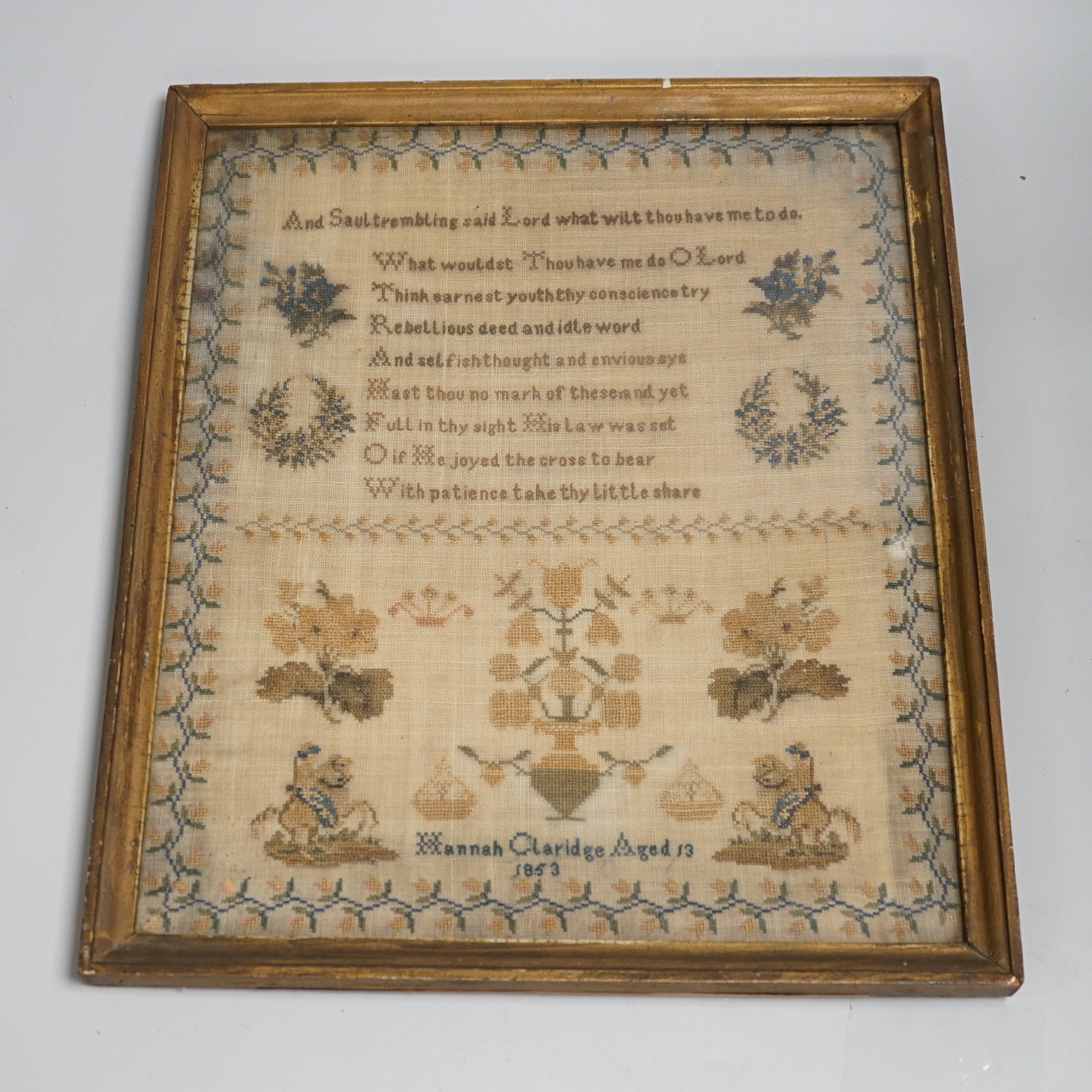 A mid 19th century framed sampler worked by Hannah Clarice, aged 13, 1853, embroidered with a verse and flowers, overall 42cm x 35cm